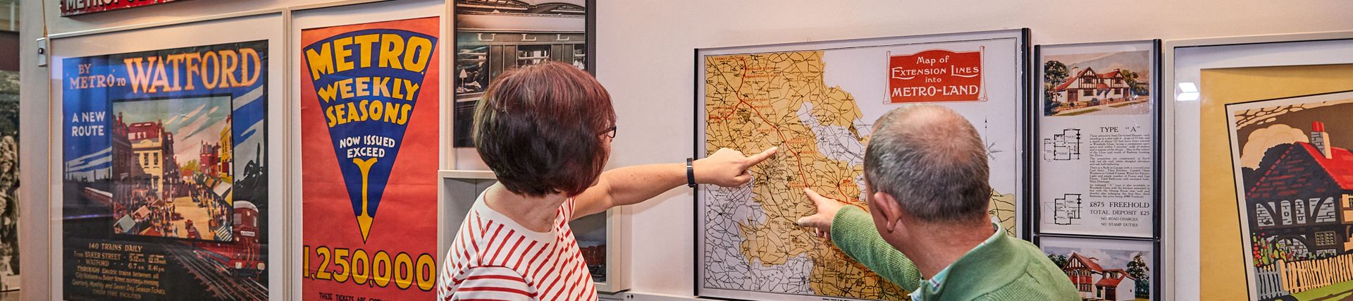 A man and a woman pointing at a vintage map of London 