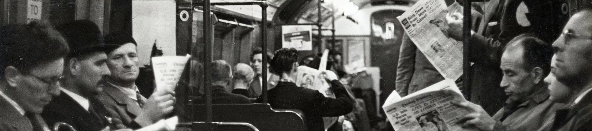 A train carriage full of people reading newspapers