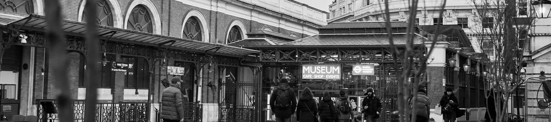 A black and white photo of people walking towards the front of the Museum