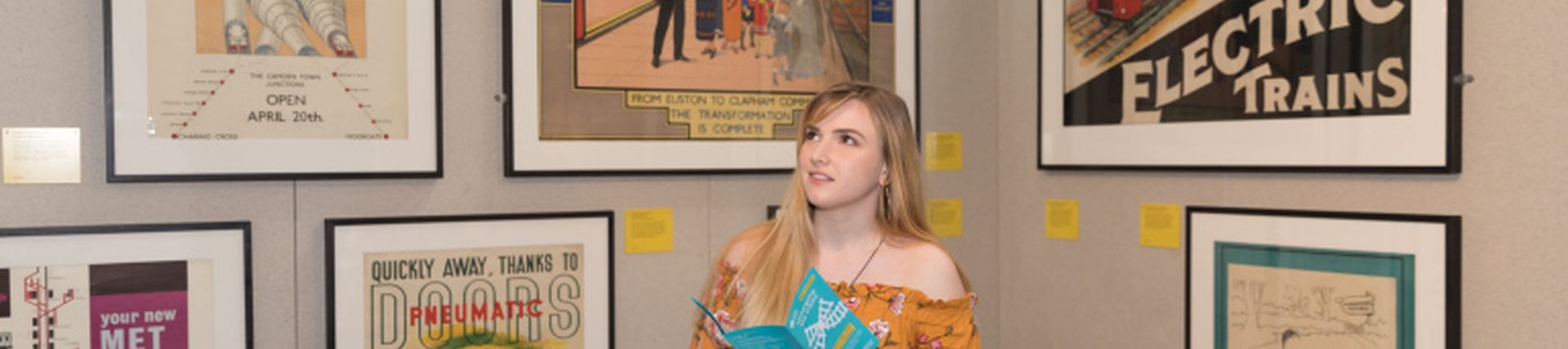 A young woman looks at posters 