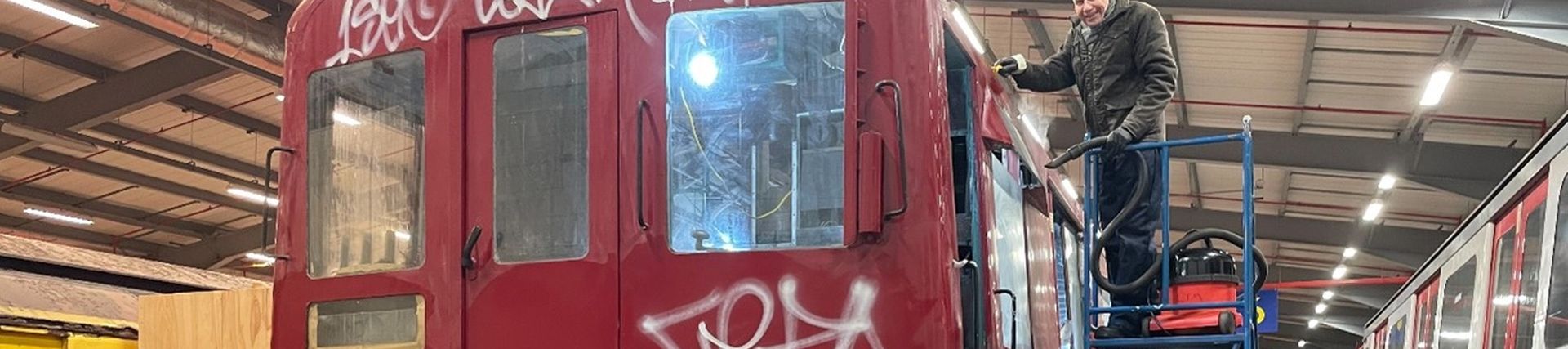A vintage tube train covered in graffiti 