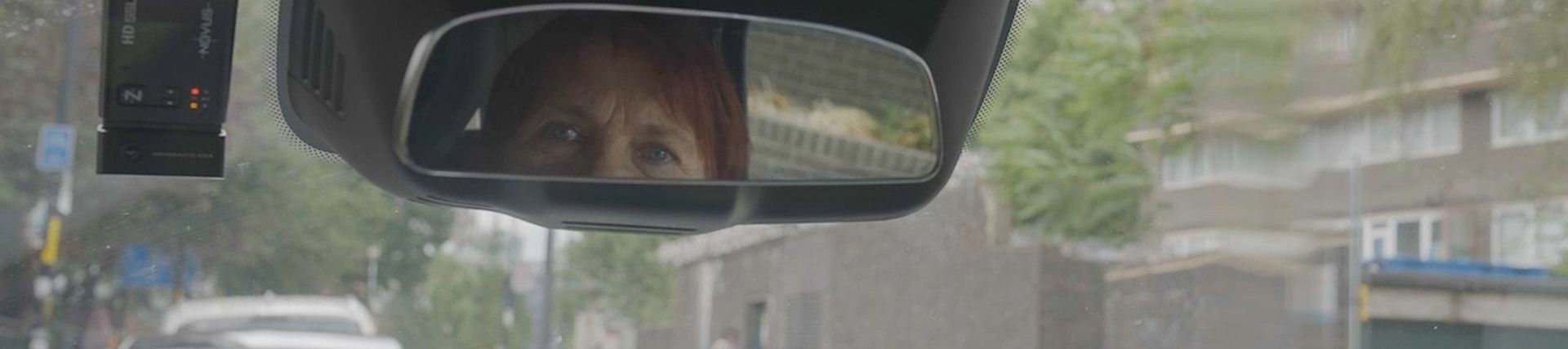 Taxi driver's eyes reflected in their car mirror